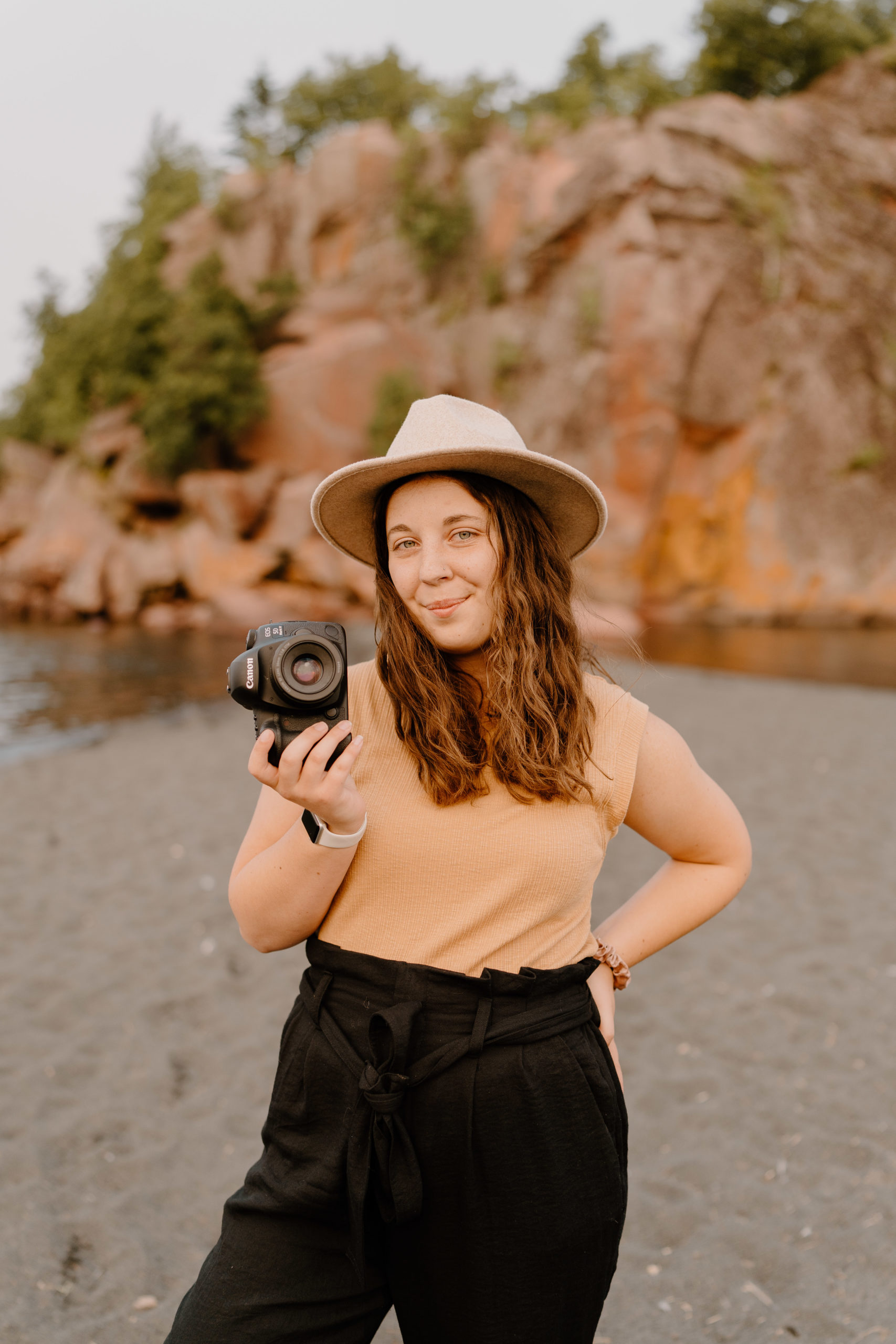 Woman holding camera at beach
