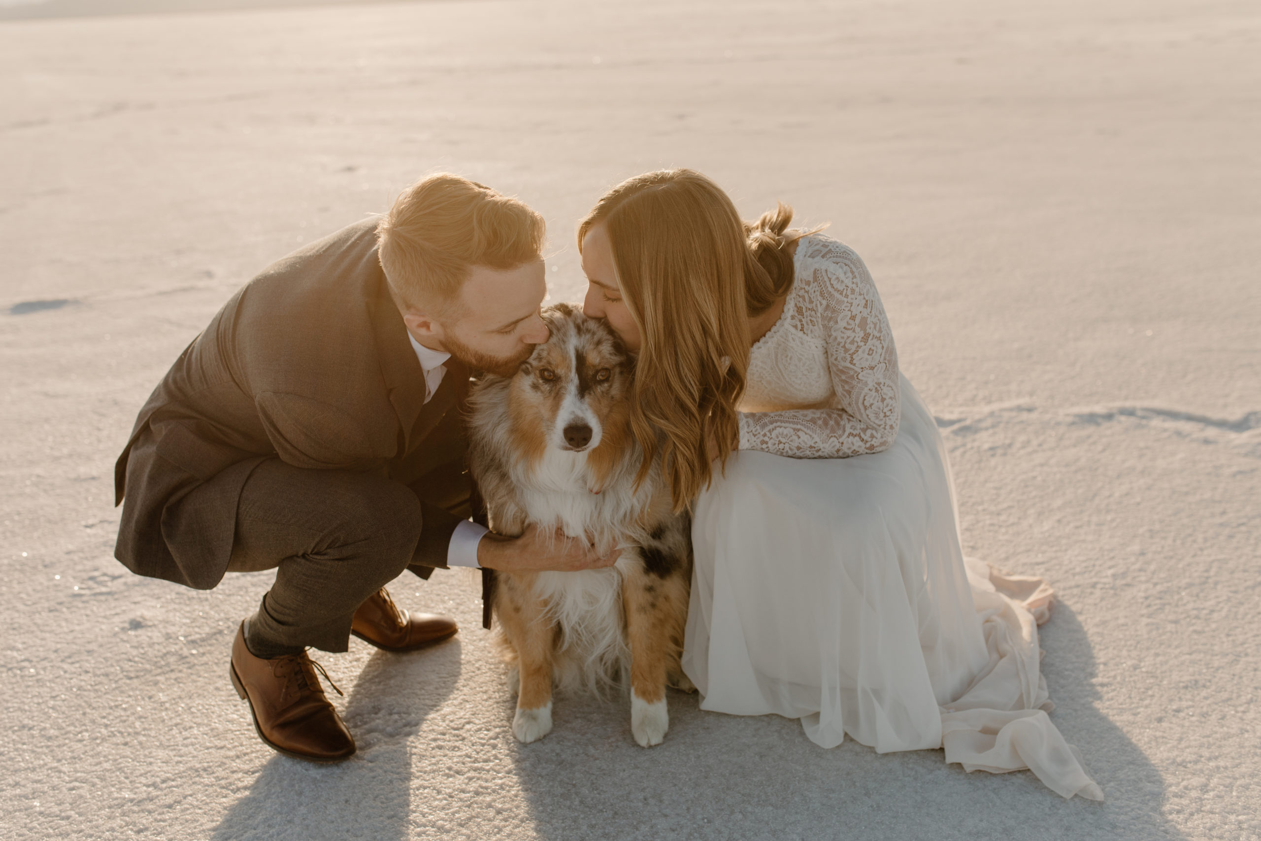 bride and groom hugging dog at elopement at bonneville salt flats utah