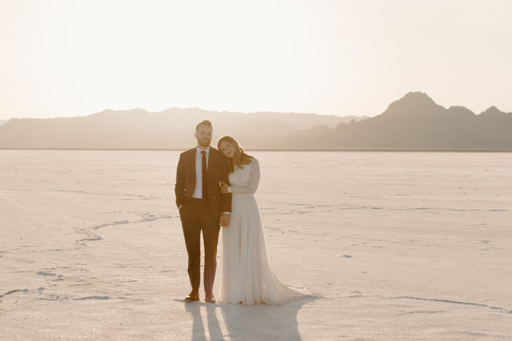 bride and groom standing next to each other at Utah Bonneville Salt Flats