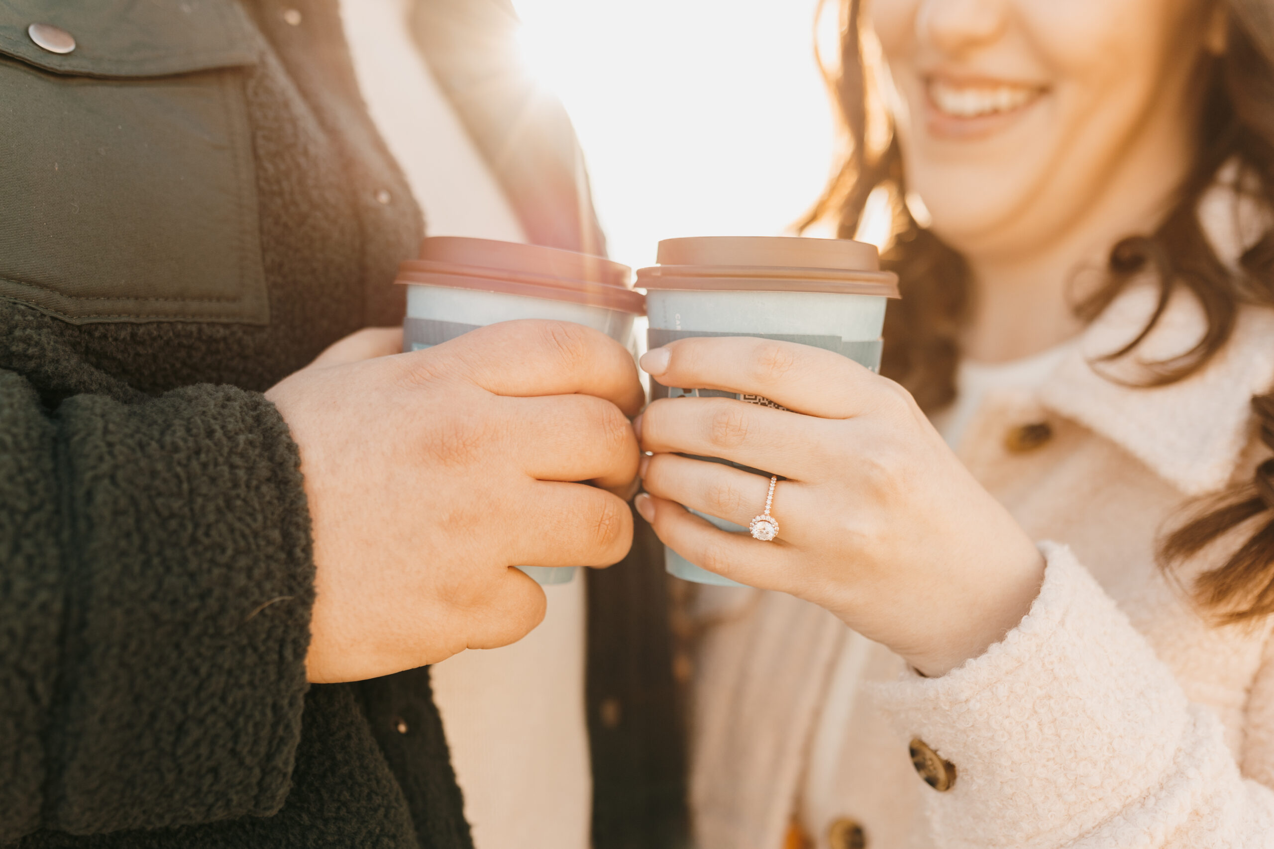 Couple holding caribou coffee in their hands for their engagement photos