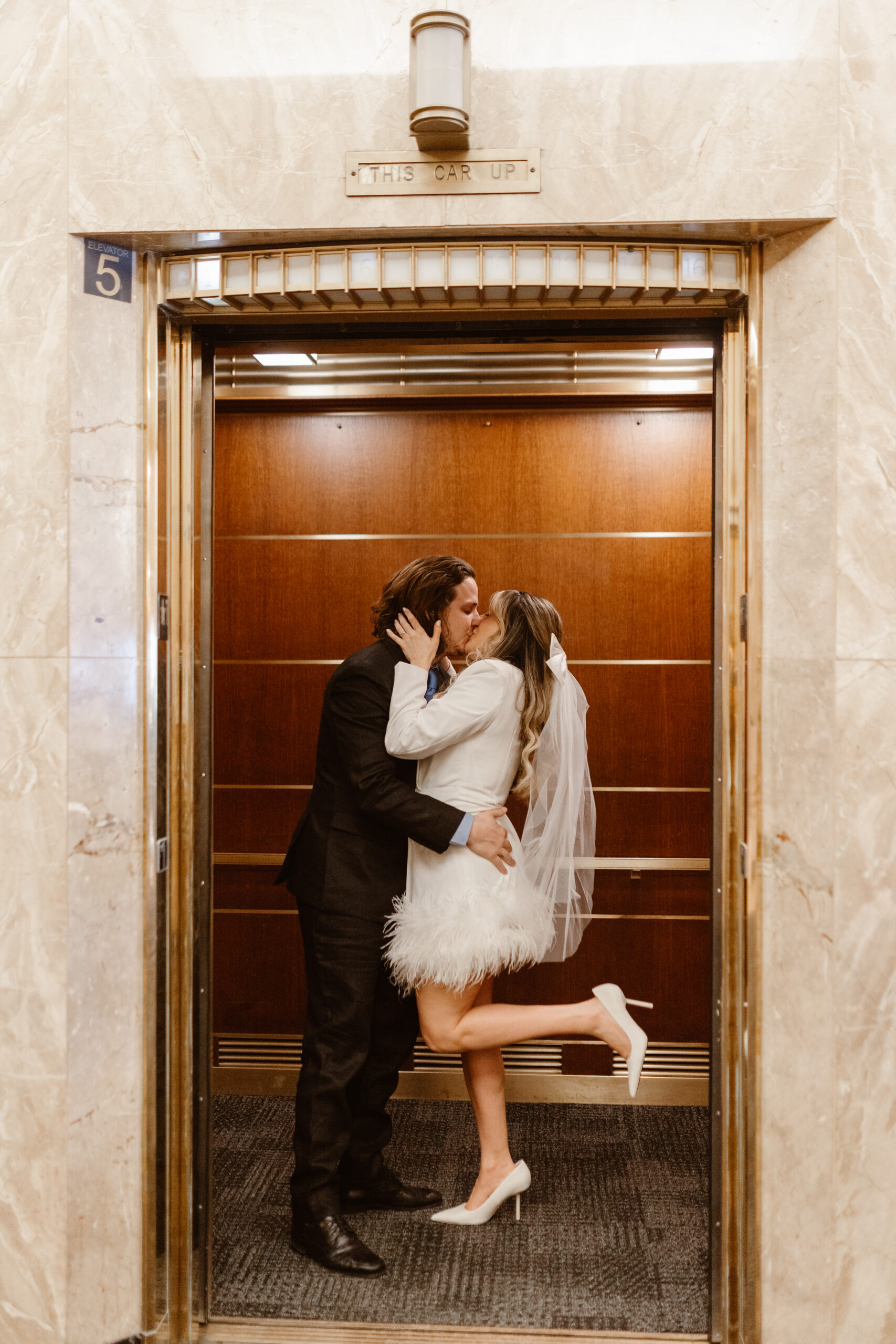 bride and groom kiss in an elevator at their courthouse elopement