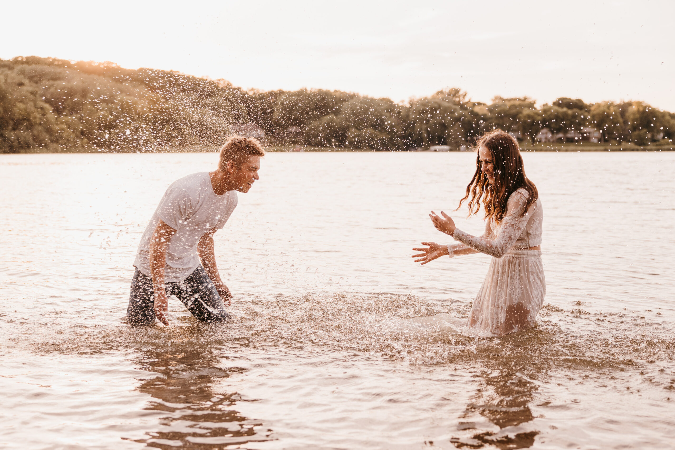 Couple splashing each other in the lake at Fish Lake Park in Maple Grove